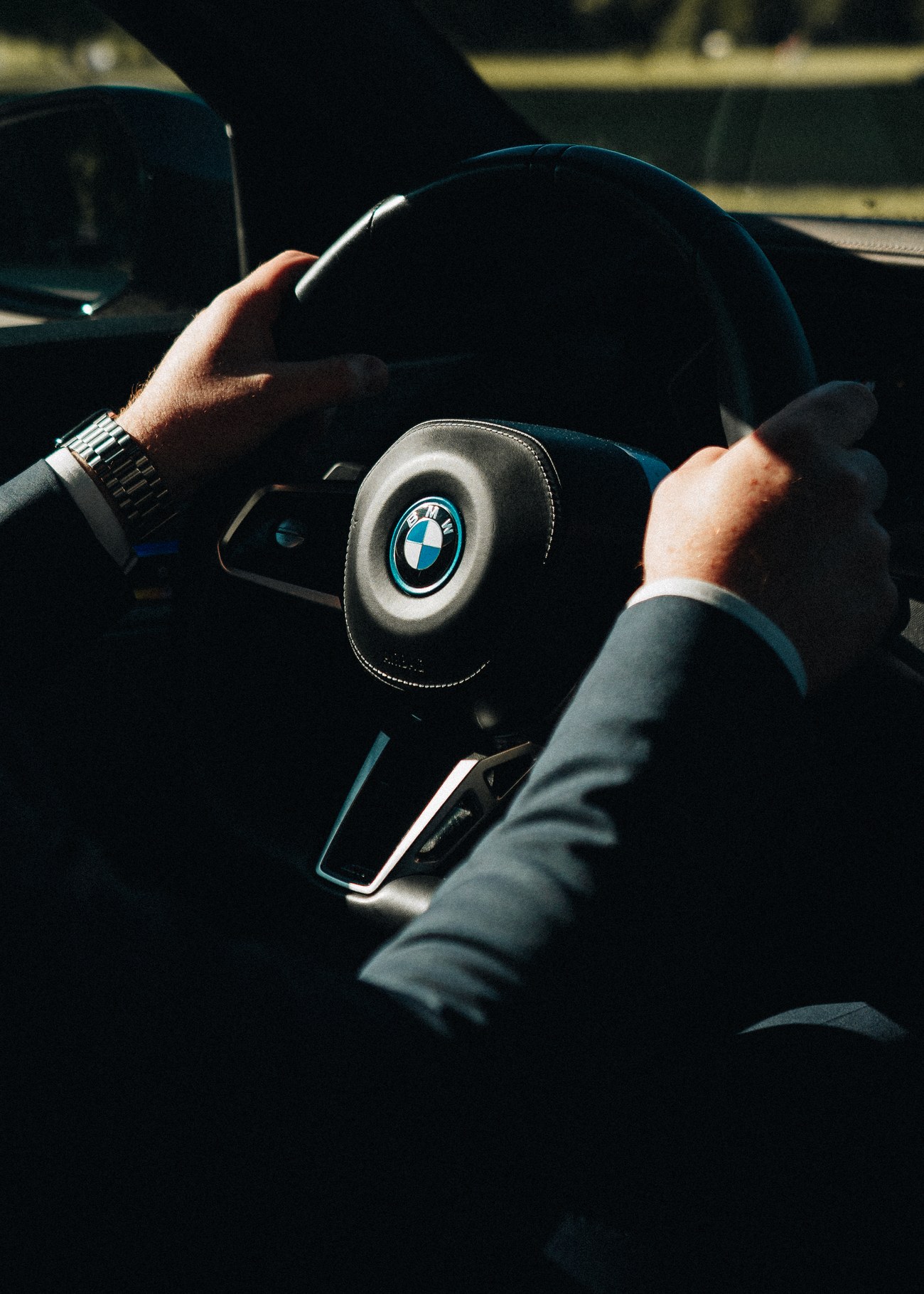 LuxLimo-chaufførens hænder på rattet i en BMW i7