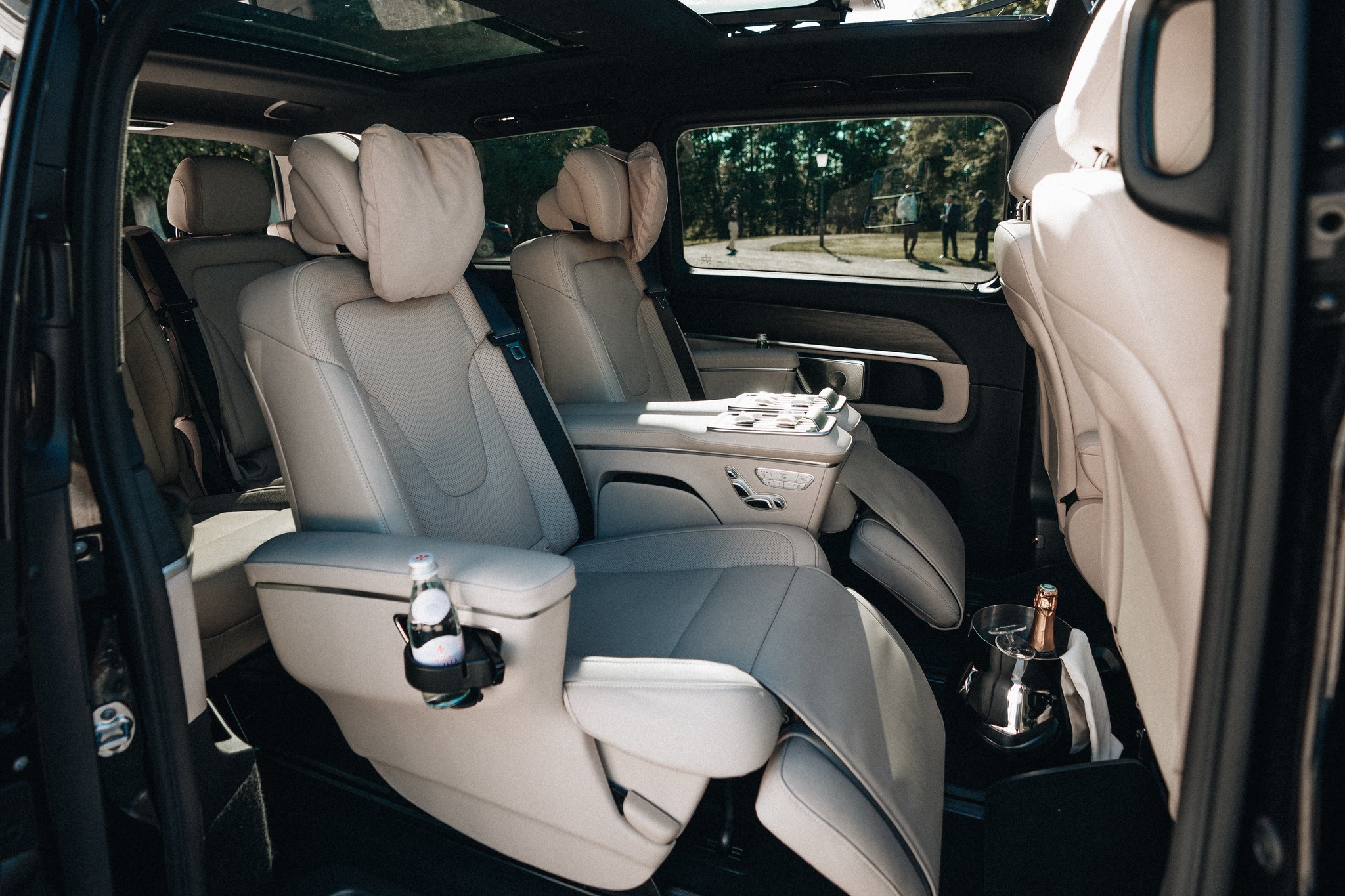 Cabin of the Mercedes-Benz EQV VIP with the table and a bottle on ice