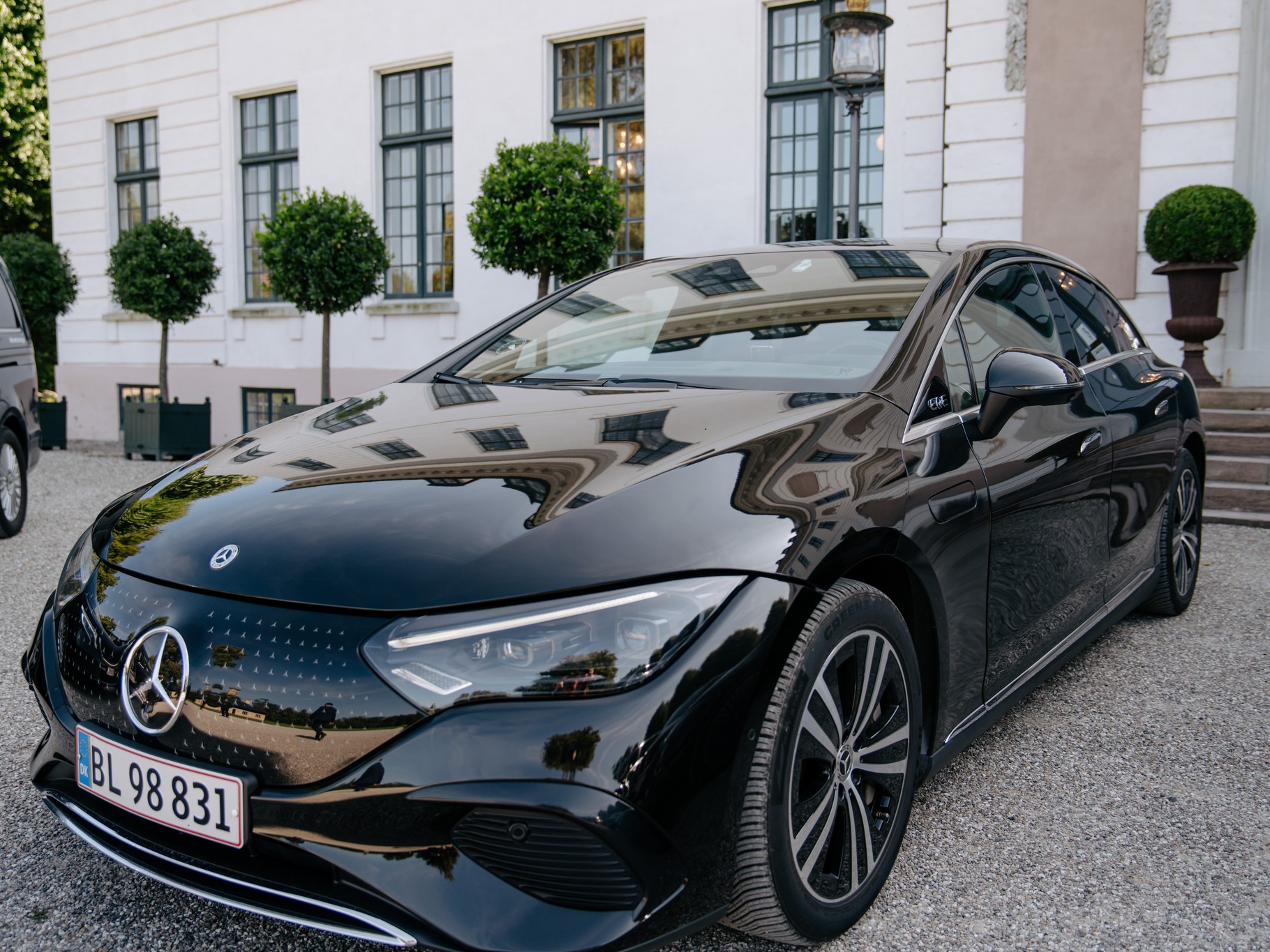 Mercedes-Benz EQE, the LuxLimo Business, in front of a Danish manor house