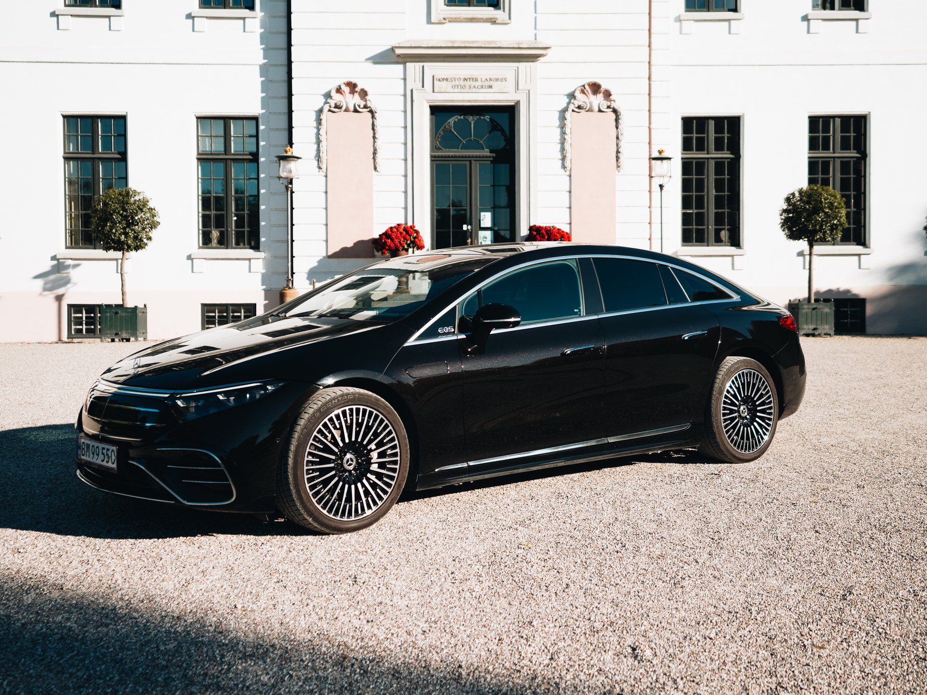Mercedes-Benz EQS in profile in front of a Danish manor house